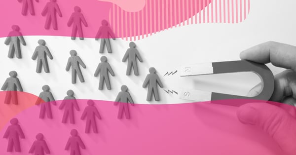 Hand holding a U-shaped magnet attracting small human icons, representing how inbound marketing strategically attracts new clients.