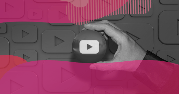 Mão segurando um ícone de play do YouTube sobre fundo com botões de reprodução, representando a criação de canal no YouTube para empresas.