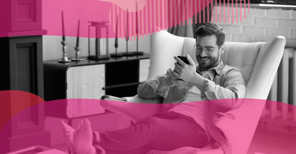 Homem relaxado em uma poltrona usando o celular, representando o uso constante de smartphones no dia a dia e seu papel no mobile marketing.