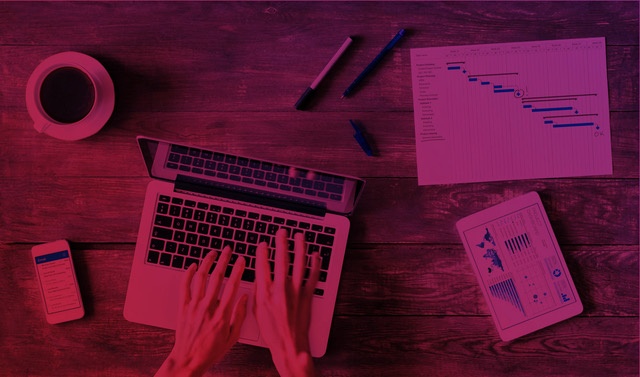 Person using a notebook at a table with graphs, tablet and performance indicators, symbolizing the analysis of metrics in inbound sales strategies.