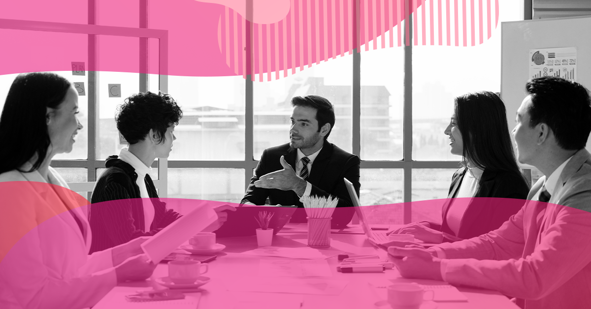 Grupo de profissionais reunidos ao redor de uma mesa em ambiente corporativo, conversando de forma colaborativa durante uma reunião de planejamento de estratégia de SEO.