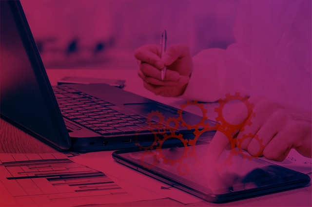 Person using a laptop and a tablet at the same time, with digital graphics and gears superimposed, representing the choice between SEO and SEM strategies in educational campaigns.