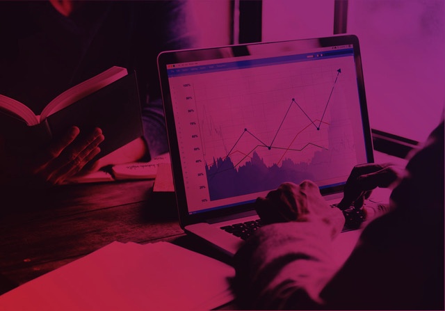 Caption: Person analyzing growth chart on a notebook, representing increased enrollments through inbound sales tactics.