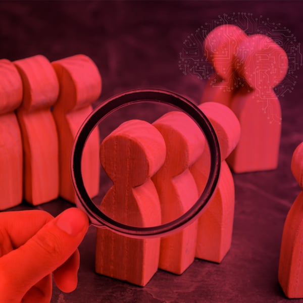 Image with wooden figures representing people, being observed through a magnifying glass, symbolizing the analysis of consumer behavior.