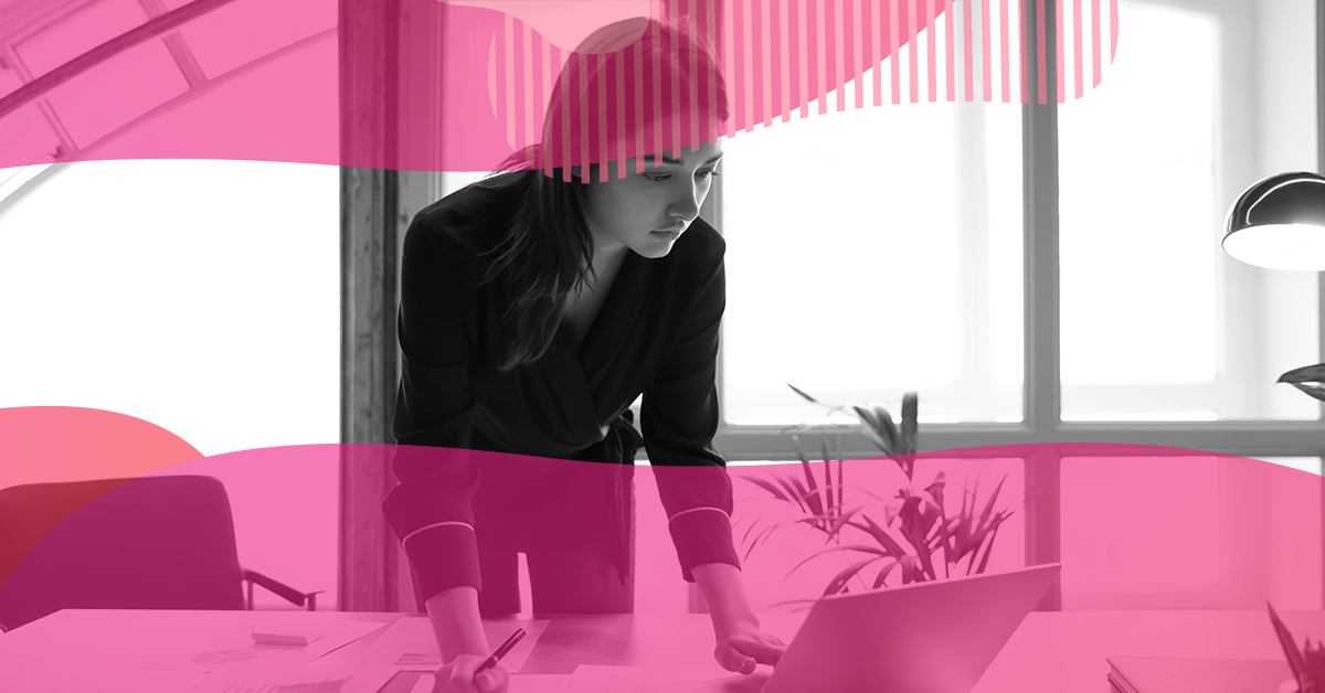 Mulher analisando dados e gráficos em mesa de trabalho, simbolizando a aplicação da avaliação diagnóstica em estratégias de marketing educacional.