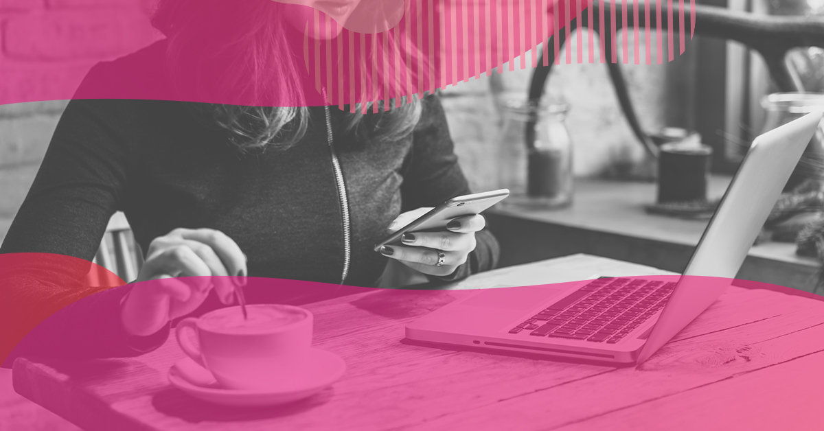 Mulher usando o celular e o notebook em um café, simbolizando o uso de blogs como estratégia de marketing digital.