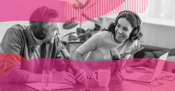 Homem e mulher usando fones de ouvido e microfones enquanto gravam um podcast em uma mesa de trabalho, simbolizando a produção de podcasts para marketing de negócios.