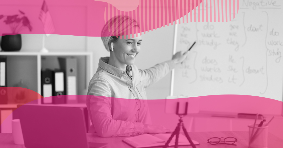 Mulher explicando conteúdo em quadro durante aula online, simbolizando o planejamento de uma régua de comunicação eficiente para engajamento e retenção.