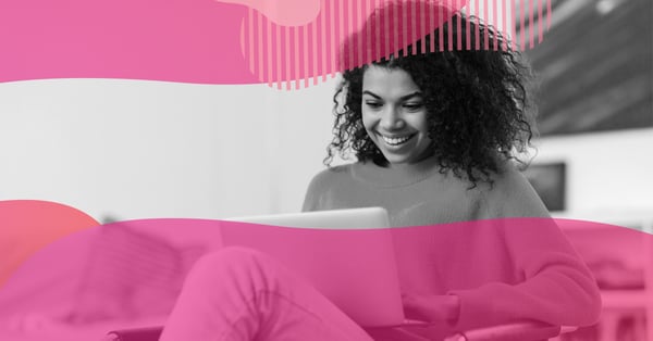 Mulher sorrindo usando notebook, representando saúde física e mental no trabalho e autocuidado na rotina digital.