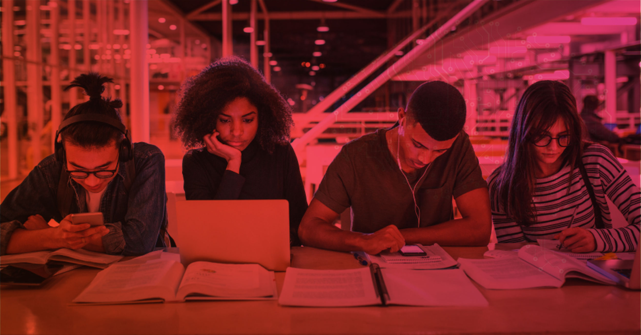 Alunos reunidos em mesa estudando e utilizando smartphones, provavelmente em redes sociais.